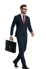 Sticker - businessman walking with briefcase on hand looking ahead serious