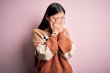 Young Beautiful Asian Woman Wearing Animal Print Fashion Sweater Over Pink Isolated Background With Sad Expression Covering Face With Hands While Crying. Depression Concept.