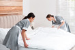 © New Africa - Young chambermaids making bed in hotel room