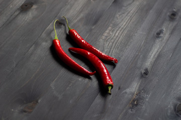 Wall Mural - red chili peppers on black wooden background