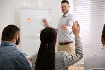 Wall Mural - Young woman raising hand to ask question at business training in conference room