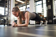© Seventyfour - Full length portrait of sportive young woman doing plank exercise during strength workout in modern gym, copy space