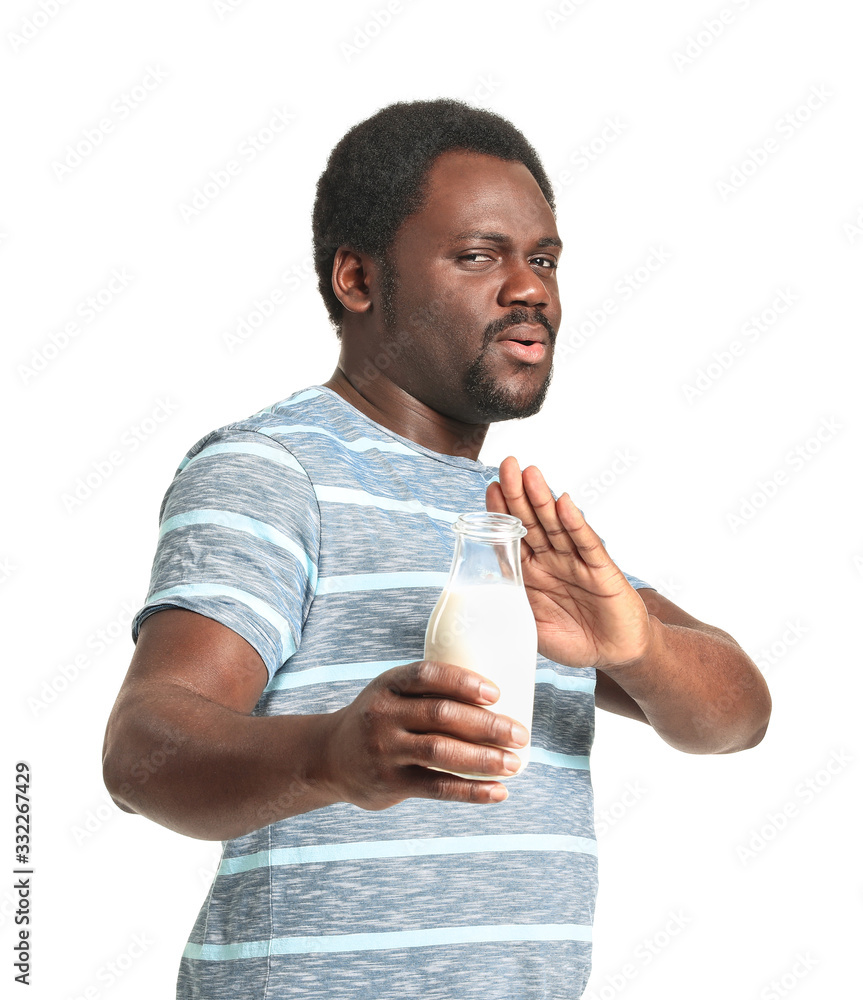 Young African-American man with dairy allergy on white background