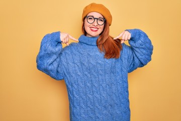 Poster - Young beautiful redhead woman wearing french beret and glasses over yellow background looking confident with smile on face, pointing oneself with fingers proud and happy.