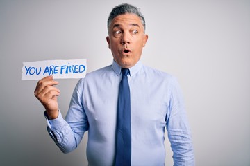 Poster - Middle age grey-haired man fired with problems holding paper with you are fired message scared in shock with a surprise face, afraid and excited with fear expression