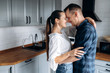 © Kateryna - Cuddling and happy couple in love in the kitchen