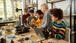 © Svitlana - Productivity is the best for us. Group of smart kids listening to their male teacher while looking at 3d printer and plastic detail prototype at robotics school lesson