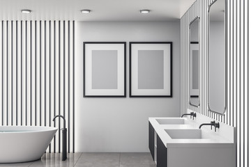 Bathroom interior with white bath and two poster on wall.