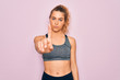 © Krakenimages.com - Young beautiful blonde sportswoman with blue eyes doing exercise wearing sportswear Pointing with finger up and angry expression, showing no gesture