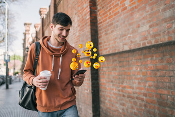 man using smartphone sending emojis.
