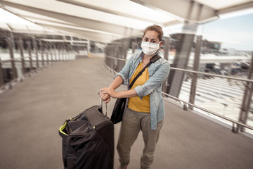 Wall Mural - Traveler with face mask affected by coronavirus travel ban and COVID-19 pandemic flight restrictions