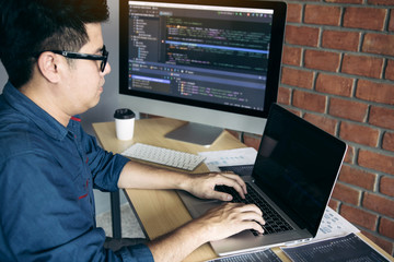 Asian man working code program developer computer web development working design software on desk in office.