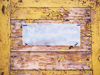 Shabby wooden planks with cracked yellow colored old paint