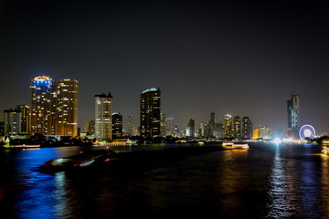 Wall Mural - City at night with light bokeh and water reflection