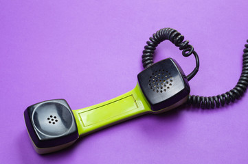 Vintage telephone handset. phone receiver on purple background. old communication technology. copy space