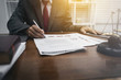© makibestphoto - Middle-age of male lawyer working with legislation contract paper in courtroom, attorney justice and law concept.