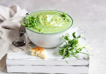 Wall Mural - Vegan cream soup with avocado and spinach served with micro greens and bread. Diet food concept. Vegetarian and vegan food. 
