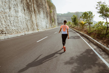 Wall Mural - Fitness sport girl resting after intensive run, young attractive runner taking break after jogging outdoors