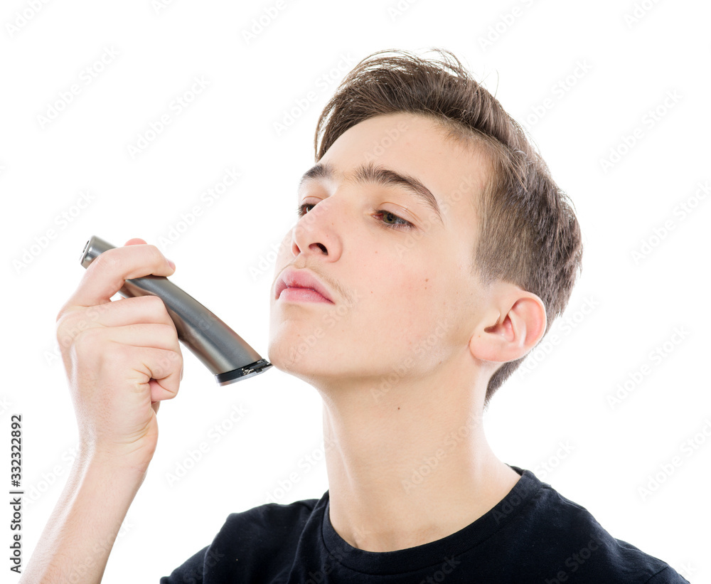 Teenage boy is shaving at first time his mustaches with an electric ...