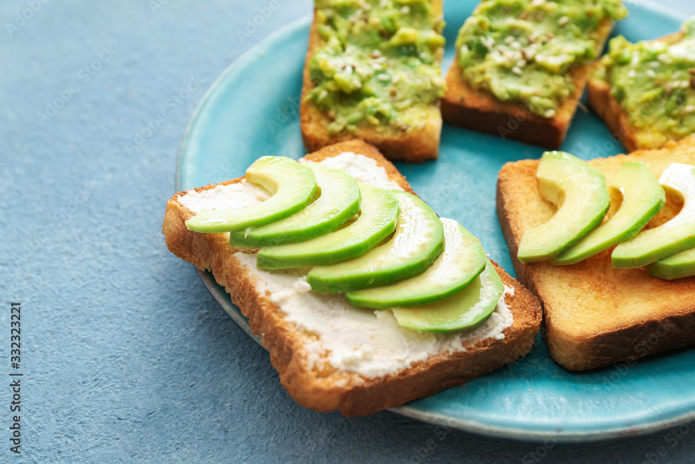 Plate with tasty avocado sandwiches on color background