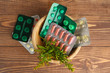 © Pixel-Shot - Bowl with plant based pills on wooden background