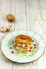 draniki with mushrooms and cranberries in sour cream sauce on white wooden background in rustic styl