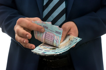 man in suit counts profits. men's hands convert hryvnia. 1000 new banknotes, Ukrainian money.