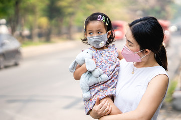 Mum and daughter standing along the road wearing face mask protect filter against air pollution (pm2.5) and Covid 19.