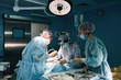 © Georgii - Medical team in the operating room, dark background. The theater of the operating room, an international team of professional doctors in a modern operating room are conducting an operation. Saving
