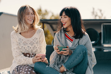 Two attractive girls enjoy a tea party