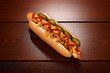 © Yuriy Afonkin - Danish hot dog with pickled cucumbers, fried onions, ketchup and mustard. On a wooden table. View from above.