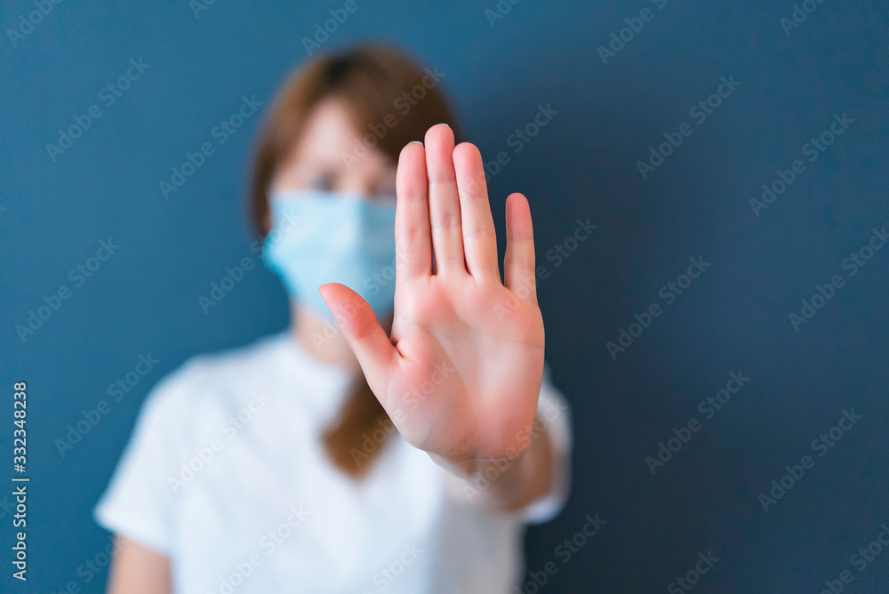 Coronavirus concept. Girl wearing mask for protection from disease and show stop hands gesture for stop corona virus outbreak. Global call to stay home. - obrazy, fototapety, plakaty 