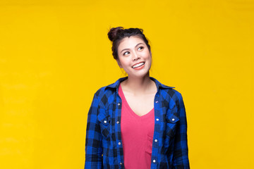 Image of feeling smile and happy. Cheerful young asian woman with brunette long hair in casual shirt smiling with teeth on yellow background. Female face expressions and emotions concept.