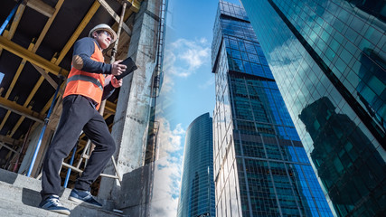 Construction of skyscrapers. Team leader at a construction site. Architect imagines what a skyscraper looks like. Tall buildings on the background sky. Concept - work in a large construction company