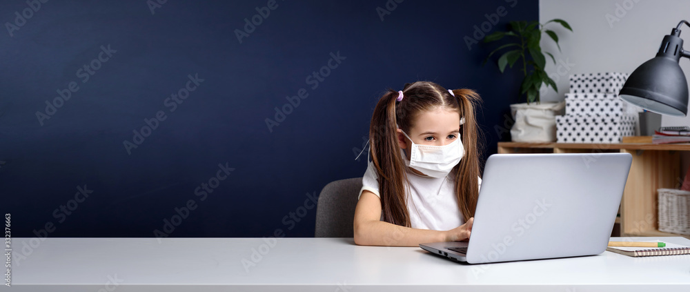 Distance learning online education. schoolgirl in medical mask studying at home, working at laptop notebook and doing school homework. coronavirus quarantine. - obrazy, fototapety, plakaty 
