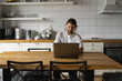 © Volodymyr_sh - Freelancer working from home on the kitchen and using laptop. Bearded man working with a laptop and reading bad news. Handsome successful self entrepreneur sitting and working at his modern home.
