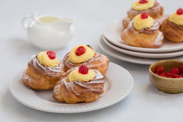 Wall Mural - Italian pastry - zeppole di San Giuseppe - baked cream puffs made from choux pastry, filled and decorated with custard cream and cherry. It is eaten to celebrate Saint Joseph's Day.