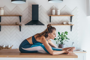 Wall Mural - Woman leans forward stretches her back and legs