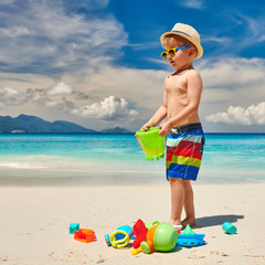 Wall Mural - Three year old toddler playing on beach