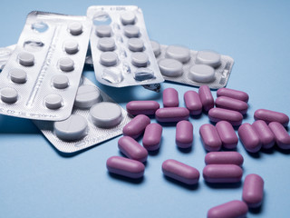 Tablets. Many tablets are on a blue background,  Drugs and pills prescription background. Pharmaceutical preparation.