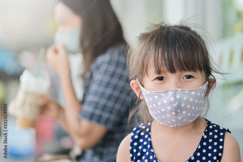 Little girl has fabric mask protect herself from Coronavirus,New Normal child leave the house with a mask on her nose for safety outdoor activity after COVID-19 outbreak,illness or Air pollution - obrazy, fototapety, plakaty 