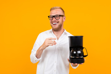 peppy guy holding a coffee machine on a yellow background with copy space