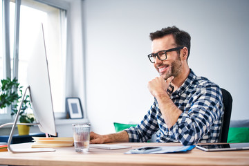 happy freelancer working on computer from home office