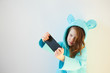 © sarymsakov.com - Cheerful Little Girl 7 years old make a Selfie on the White Background. Concept Social Media Addiction.