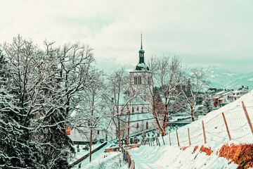 Wall Mural - Church with Alpine mountains of Gruyeres winter