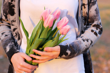 Wall Mural - Flowers in the hands of a girl. Tulips in spring