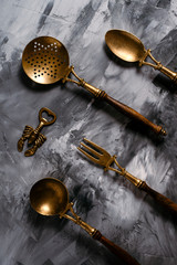 Photo of the vintage old wonderful brass metal with wood hand cutlery set on a dark background with dry leaves