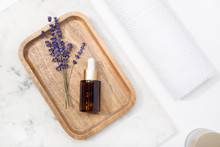 Top View Lavender Flower And Its Essential Oil On A Bottle Drop At A Marble Table On Wooden Tray