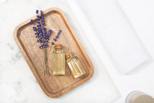 Top View Lavender Flower And Its Essential Oil On A Bottle At A Marble Table On Wooden Tray
