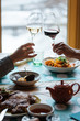© Peter Karasev/ADDICTIVE STOCK - Crop male and female hands with glasses and white and red wines toasting during dinner in modern restaurant